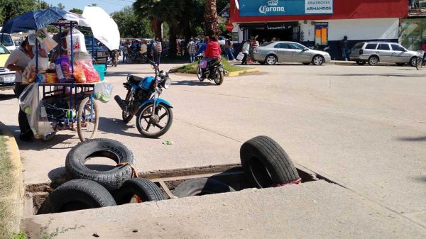 Silaoenses colocan neumáticos en colector pluvial por falta de la rejilla de protección